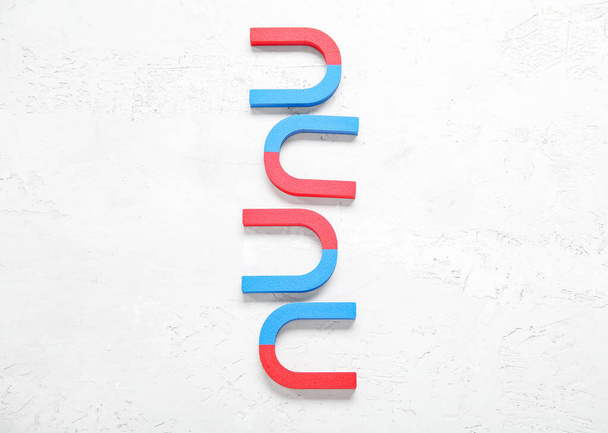 Horseshoe shaped magnets on textured white background - Foto, imagen