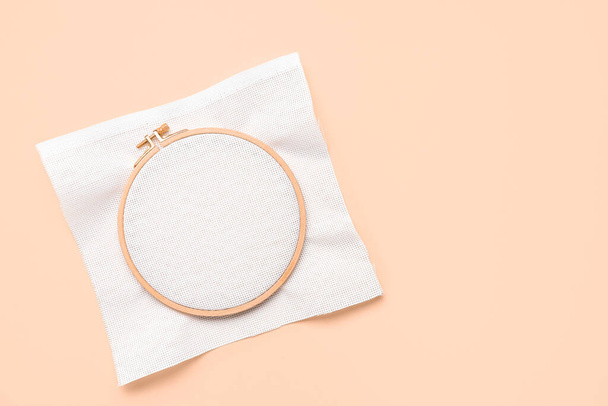 Wooden embroidery hoop with canvas on pale orange background - Foto, Imagem