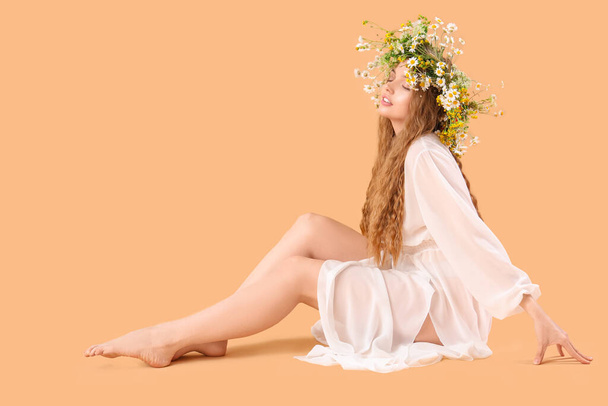 Beautiful young woman in flower wreath on beige background. Summer solstice - Foto, imagen
