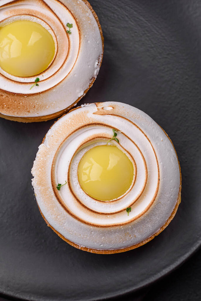 Delicious tart with citrus filling and walnut cream on a textured concrete background - Photo, Image