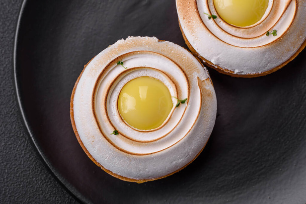 Delicious tart with citrus filling and walnut cream on a textured concrete background - Photo, Image