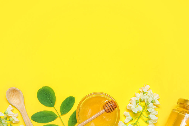 Composition with sweet honey and acacia flowers on yellow background - Фото, зображення