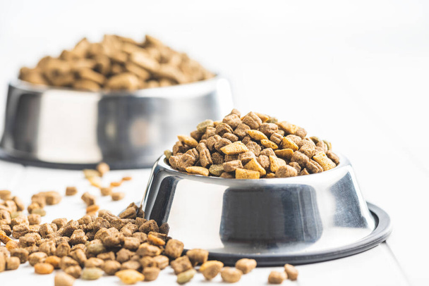 Dry kibble pet food. Dog or cat food in bowl on the white table. - Foto, afbeelding