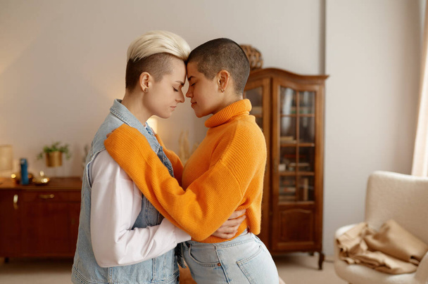 Portrait of young multiethnic lesbian woman couple standing face to face with eyes closed and head joint - Photo, Image