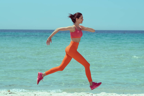 Bella donna che fa jogging sulla spiaggia. Stile alla moda e colori retrò! - Foto, immagini