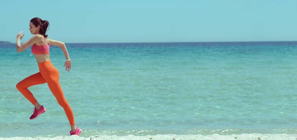 美しい女性のビーチでジョギング。ファッショナブルなスタイリングとレトロな色! - 写真・画像