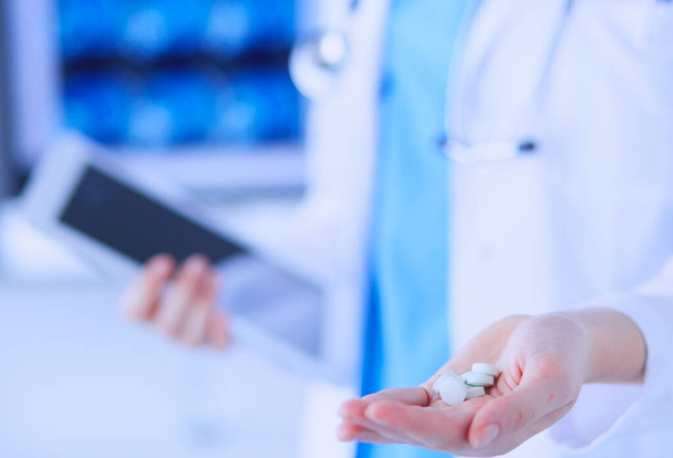 Close-up shot of doctors hands holding pills and tablet at clinic - Photo, Image