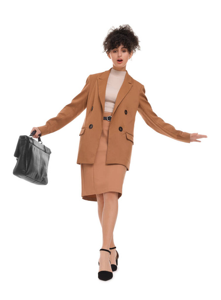 Beautiful emotional businesswoman in suit with briefcase walking on white background - 写真・画像