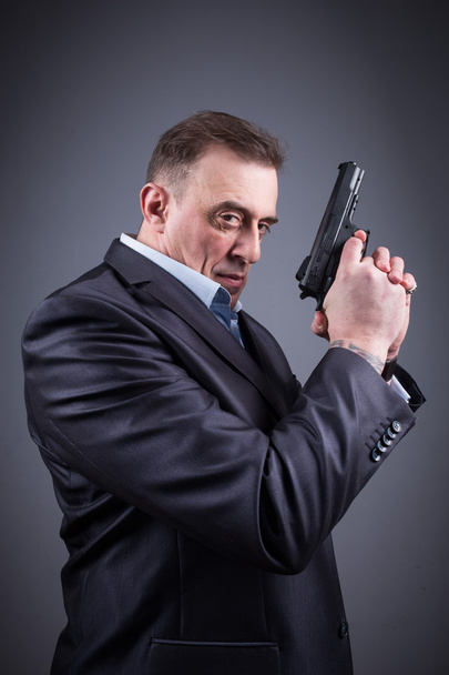 man in a business suit with a gun - Foto, Imagem