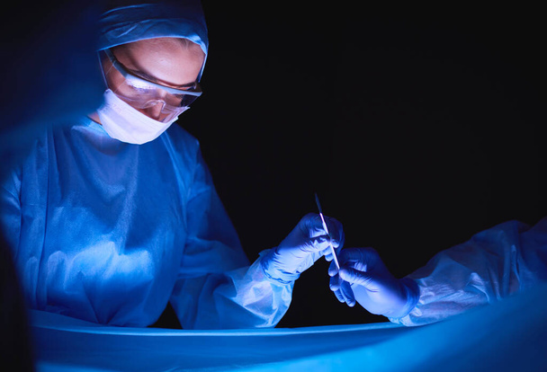Doctors team in surgery in a dark background - Photo, image