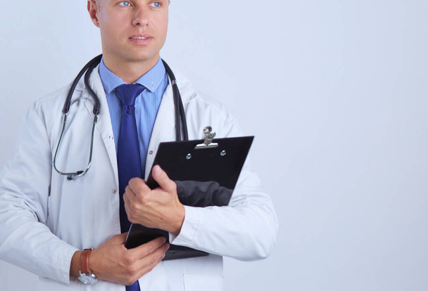 Male doctor standing with folder, isolated on white background. - 写真・画像