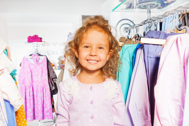 Cute girl among clothes - Foto, afbeelding