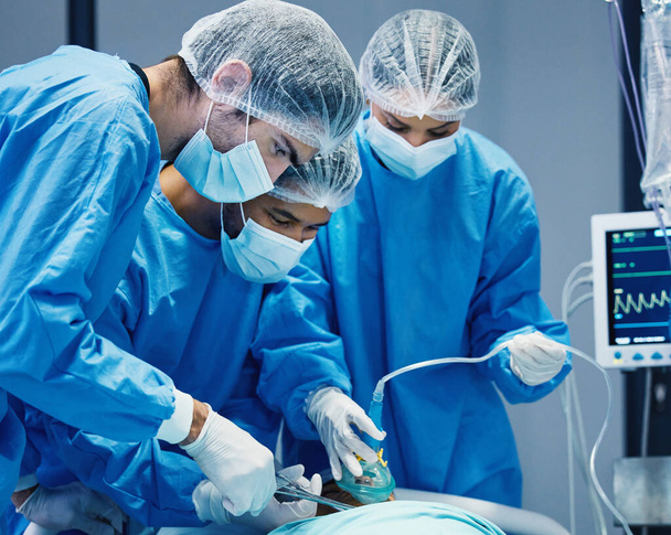 Group of doctors in surgery, healthcare and surgical procedure start with PPE and team in theatre in hospital. Medical operation, health insurance and safety gear with surgeon people in clinic. - Foto, afbeelding