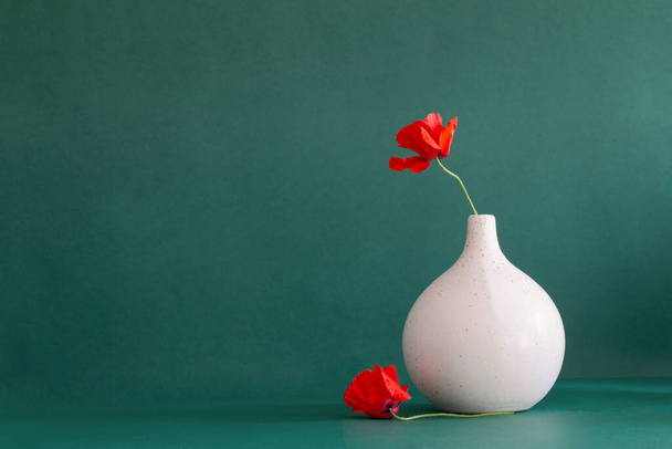 red poppies in vase on green background - Fotoğraf, Görsel