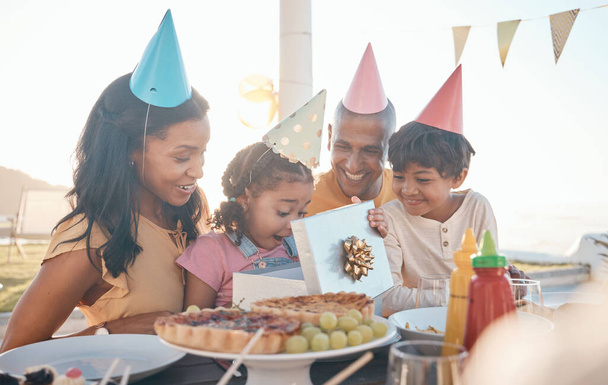 День народження, сюрприз і сім'я на відкритому повітрі для вечірки, святкування і сьогодення, щасливі і схвильовані. Батьки, діти і подарунок для дівчинки на спеціальних заходах, вау і святкування з їжею в ресторані
. - Фото, зображення