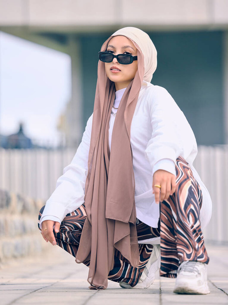 Portrait, fashion or religion with a muslim woman in the uae wearing a hijab and scarf for contemporary style. Islam, faith and burka with a trendy young islam person outside in traditional clothes. - Foto, Bild