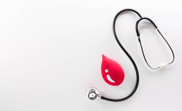 World blood donor day, doctor day and nurse day concept made from red blood drop and stethoscope on white background. - Photo, Image