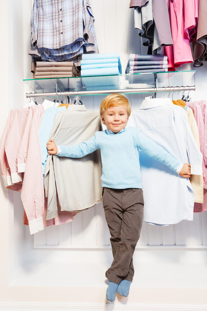 Boy standing among clothes in shop - Fotoğraf, Görsel