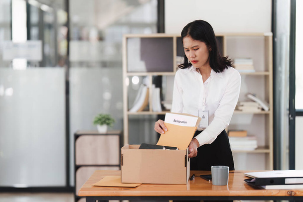 Resignation concept. Fired employee holding box of belongings in an office. - Photo, Image