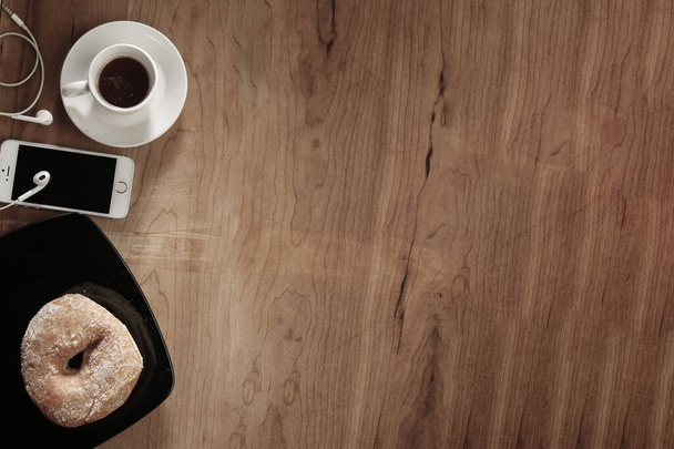 coffee cup with donut and phone on table. top view, space for your text  - Foto, imagen