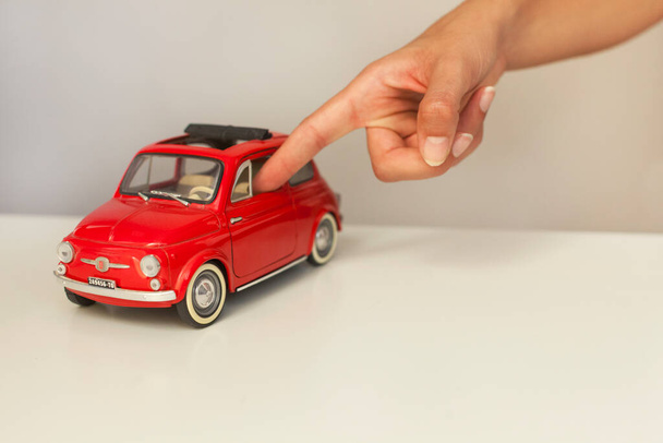 Ανθρώπινο δάχτυλο αγγίζουν αυτοκίνητο παιχνίδι - Φωτογραφία, εικόνα