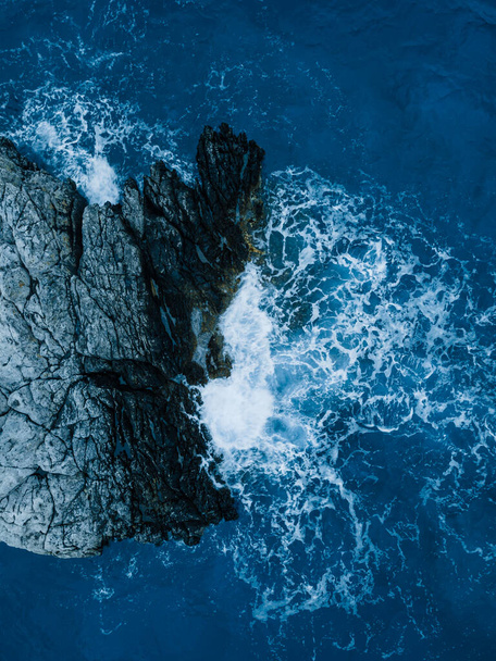 Rocky reefs and crashing waves cliffs of sea coast, aerial shot - Foto, afbeelding