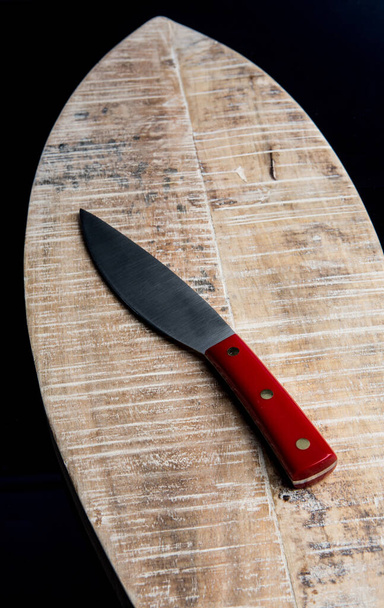 knife with red handle isolated on wooden tray - Foto, Imagen