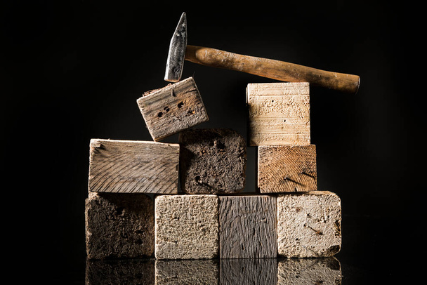 Hammer near of square wooden logs, isolated on black background - Foto, Imagem