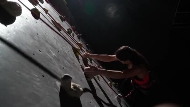 Female pro climber training on a climbing wall, practicing rock-climbing and moving up, endurance training, view from the top. - Filmagem, Vídeo