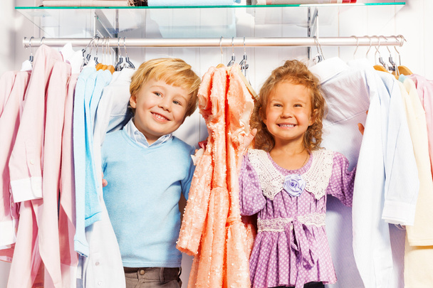 Boy and girl play hide-and-seek in clothes - Foto, Bild