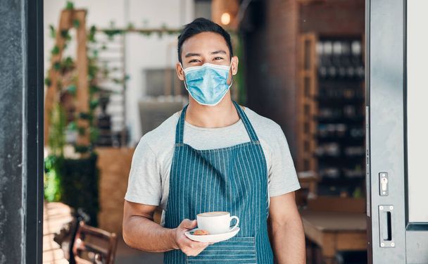 Barista, man and face mask portrait with coffee with hospitality and service in a small business. Restaurant, hot drink and cafe owner at door with latte and cappuccino of manager and entrepreneur. - Фото, изображение