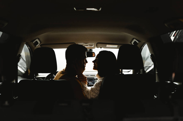 silhouette of lovers in the car. couple travel by car. close-up of faces in silhouette.lovers look at each other - Photo, Image