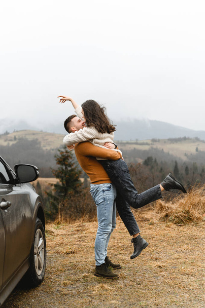 a couple in the autumn time having fun traveling. a man holds a girlfriend in his arms. happy couple on high ground. couples autumn vacation - Foto, Bild