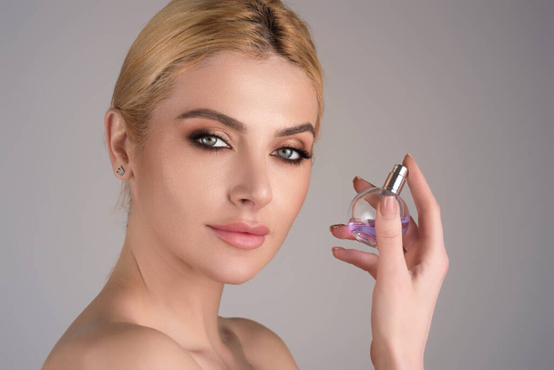 Woman with bottle of perfume smelling aroma - Foto, immagini