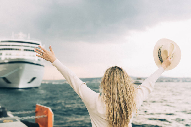 Mulher turista em pé na frente de grande navio de cruzeiro, viajar feminino.  - Foto, Imagem