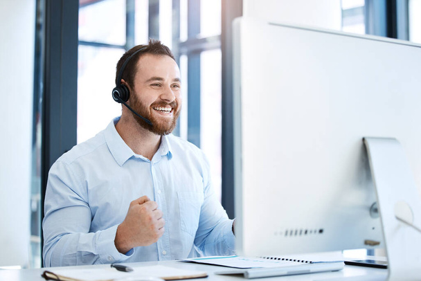 Happy man, call center and fist in celebration for winning, bonus or sales promotion at the office. Excited businessman, consultant or agent in joy for win, victory or customer service at workplace. - Фото, изображение