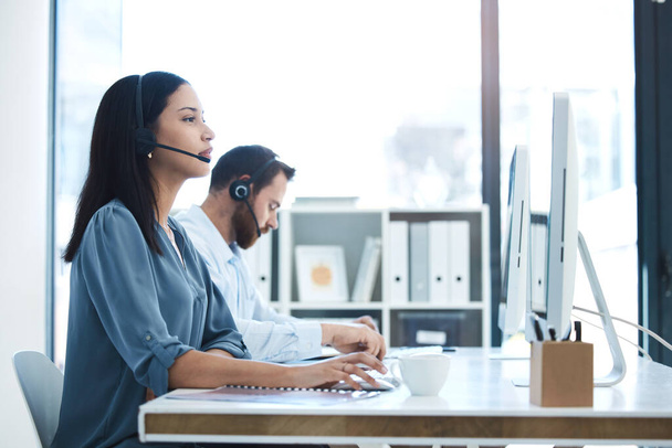 Call center, people and team in customer service, support or telemarketing on computer at the office. Woman and man consultant, agent or virtual assistant working for online agency at the workplace. - Photo, image