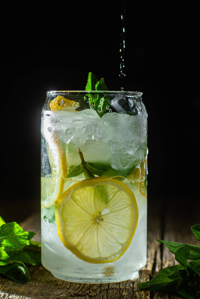 Холодний лимонад з м'ятою та лимоном та льодом на темному фоні
 - Фото, зображення