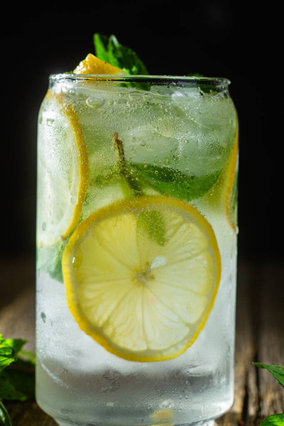 Studená limonáda s mátou a citrónem a ledem na tmavém pozadí - Fotografie, Obrázek
