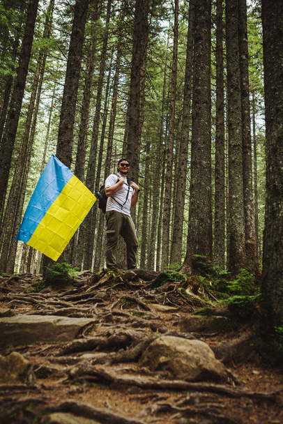 Man in Forest with Ukrainian Flag - Foto, afbeelding