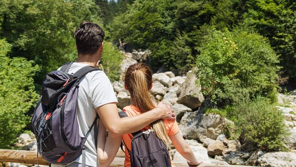 Two young hikers with backpacks, a couple in love exploring nature - Foto, Bild