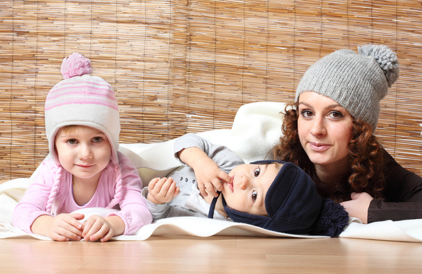 Молодая мать и ее дети одеты в теплые трикотажные изделия
  - Фото, изображение