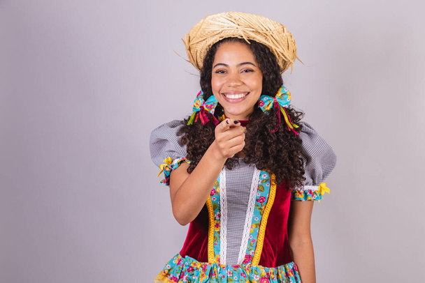 Black, Brazilian woman, wearing June party clothes, fraternization in the name of So Joo, Arraial. presenting product or advertisement on the side - Фото, зображення