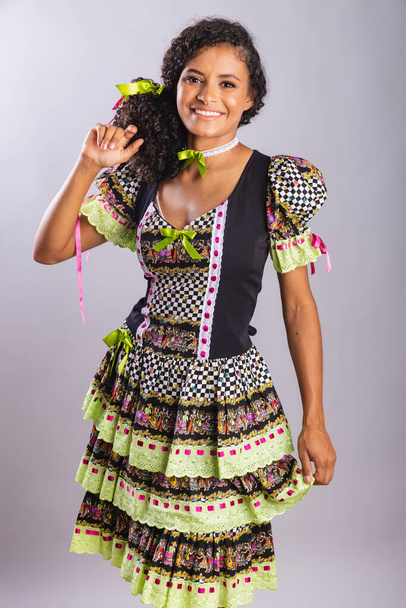 Black Brazilian woman wearing festa junina clothes. Fellowship of Saint John. Arraial, Vertical portrait. - Фото, изображение