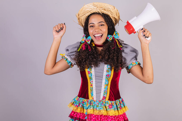 Black, Brazilian woman, wearing June party clothes, fraternization in the name of So Joo, Arraial. Shouting promotion with megaphone - Valokuva, kuva