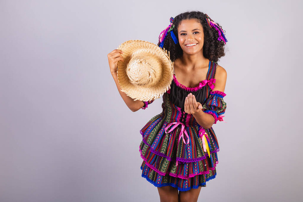 Black Brazilian woman wearing festa junina clothes. Fellowship of Saint John. Arraial, with straw hat. - Photo, image
