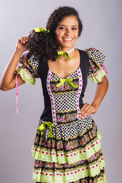 Black Brazilian woman wearing festa junina clothes. Fellowship of Saint John. Arraial, Vertical portrait. - 写真・画像