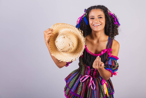 Donna brasiliana nera che indossa abiti da festa junina. Compagnia di San Giovanni. Arraial, con cappello di paglia. - Foto, immagini