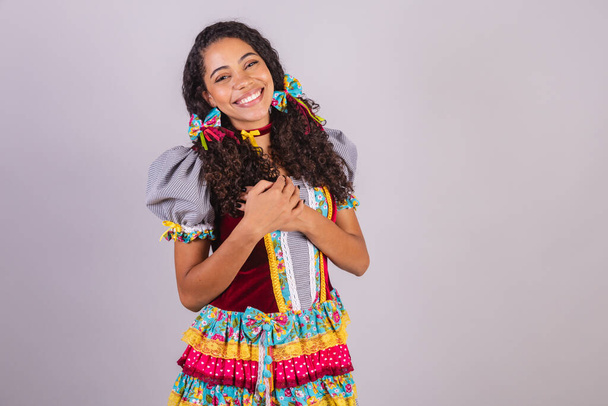 Black Brazilian woman wearing June party clothes, fraternization in the name of So Joo. Arraial heart, gratitude.  - Fotó, kép