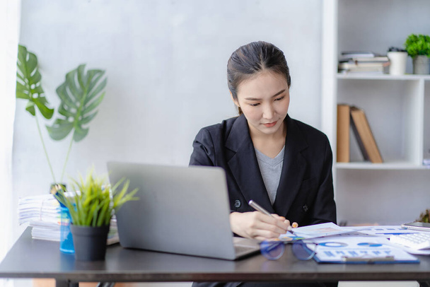 Profesjonalny azjatycki kobieta księgowy pracujący w biznes plan finansowy biuro planowania przeglądu sprawozdania księgowego sprzedaży Analityk finansowy pracujący na laptopie, koncepcja pracy online - Zdjęcie, obraz